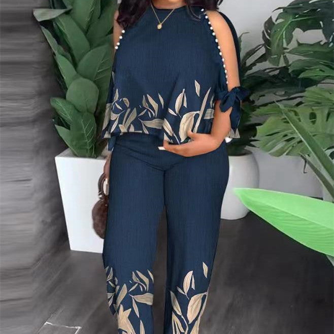 Floral summer jumpsuit in dark blue with sleeveless ruffle shoulders and white leaf print