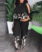 Floral summer jumpsuit in black with sleeveless ruffle shoulders and white leaf print