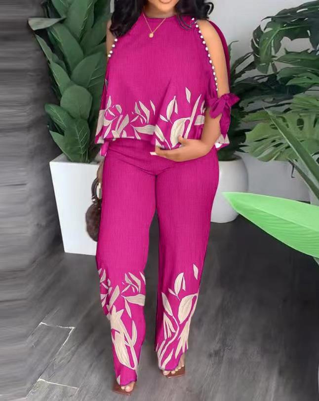 Floral summer jumpsuit in magenta with sleeveless ruffle shoulders and white leaf print