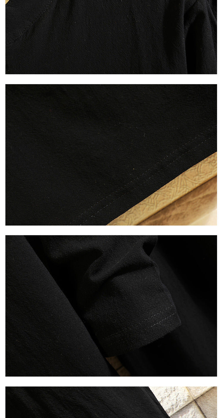 Men's black tunic fabric close-up with textured weave and seam detail