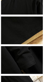Men's black tunic fabric close-up with textured weave and seam detail
