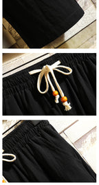 Men's black drawstring pants waist detail with white drawcord and tassels