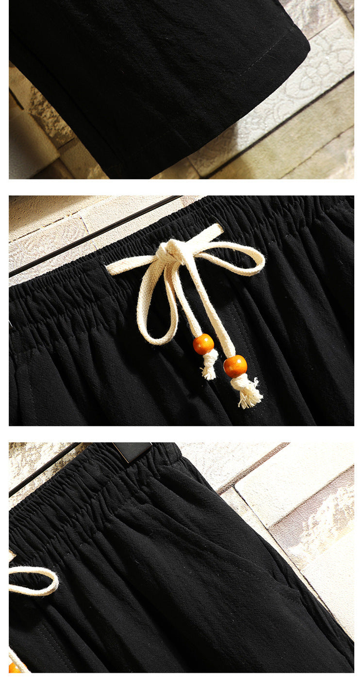 Men's black drawstring pants waist detail with white drawcord and tassels