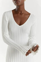 White ribbed V-neck midi dress with long sleeves, close-up of neckline and fabric