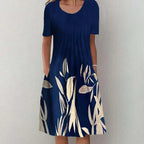 Casual floral dress in navy with cream leaf and floral pattern, short sleeves, and round neckline