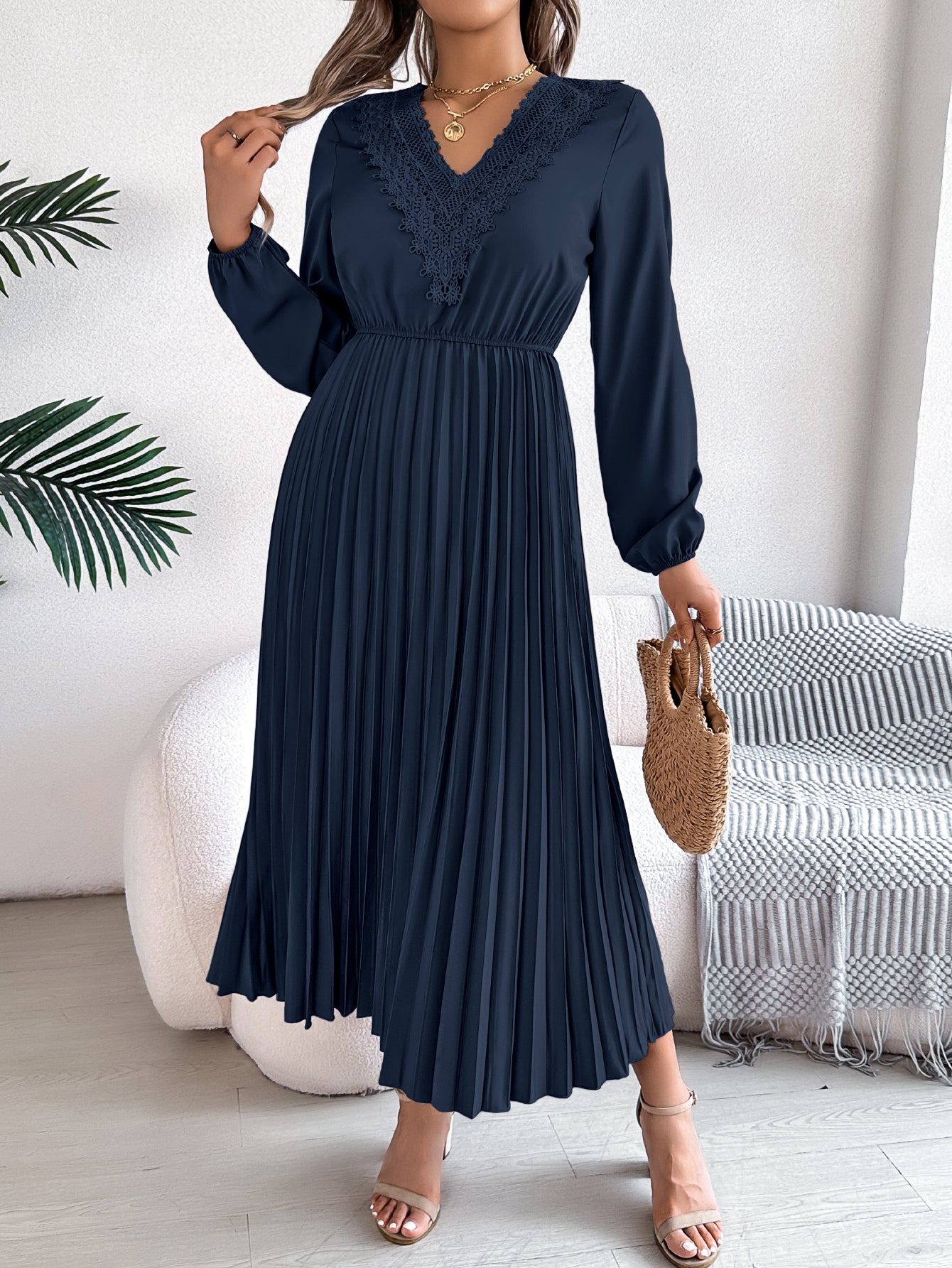 Pleated midi dress with long sleeves and lace-trim V-neck in navy blue, carrying bag