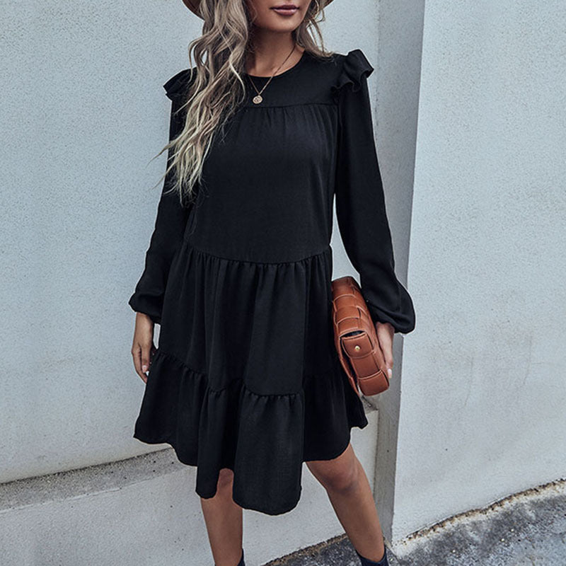 Black tiered mini dress front view with gathered waist and long cuffed sleeves
