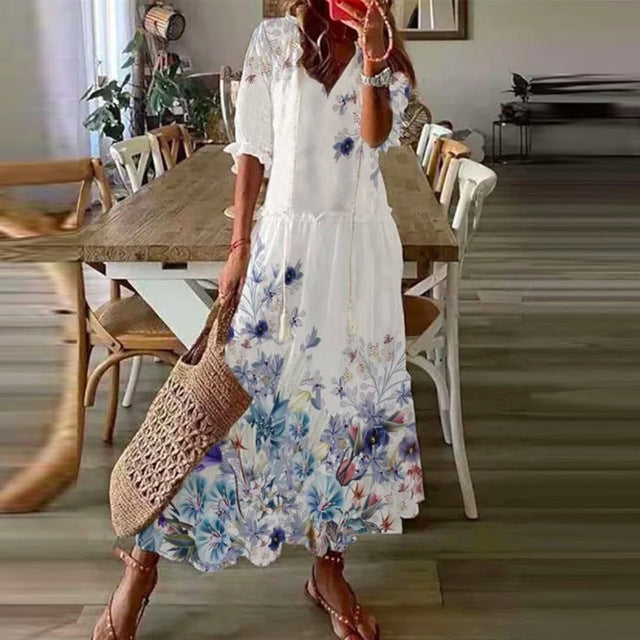 White boho maxi dress with blue floral print, short sleeves, tiered maxi length