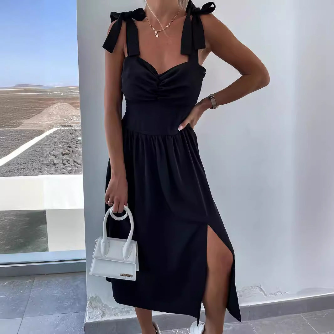 Black sleeveless summer dress with bow straps, ruched bodice and front slit midi length