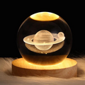Sterre™ glowing crystal ball with Saturn rings on wooden base, warm light