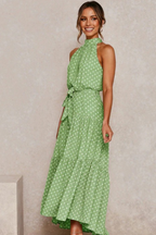 Light green sleeveless halter long dress with white polka dots and tied waist