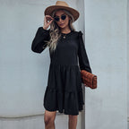 Black tiered mini dress with ruffled shoulders, round neckline, and layered skirt