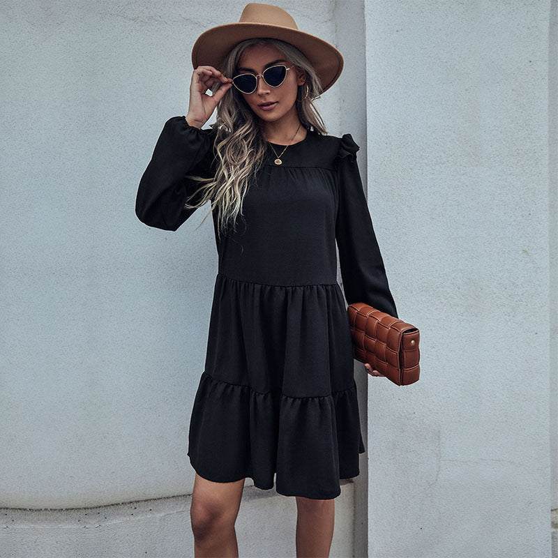 Black tiered mini dress with ruffled shoulders, round neckline, and layered skirt