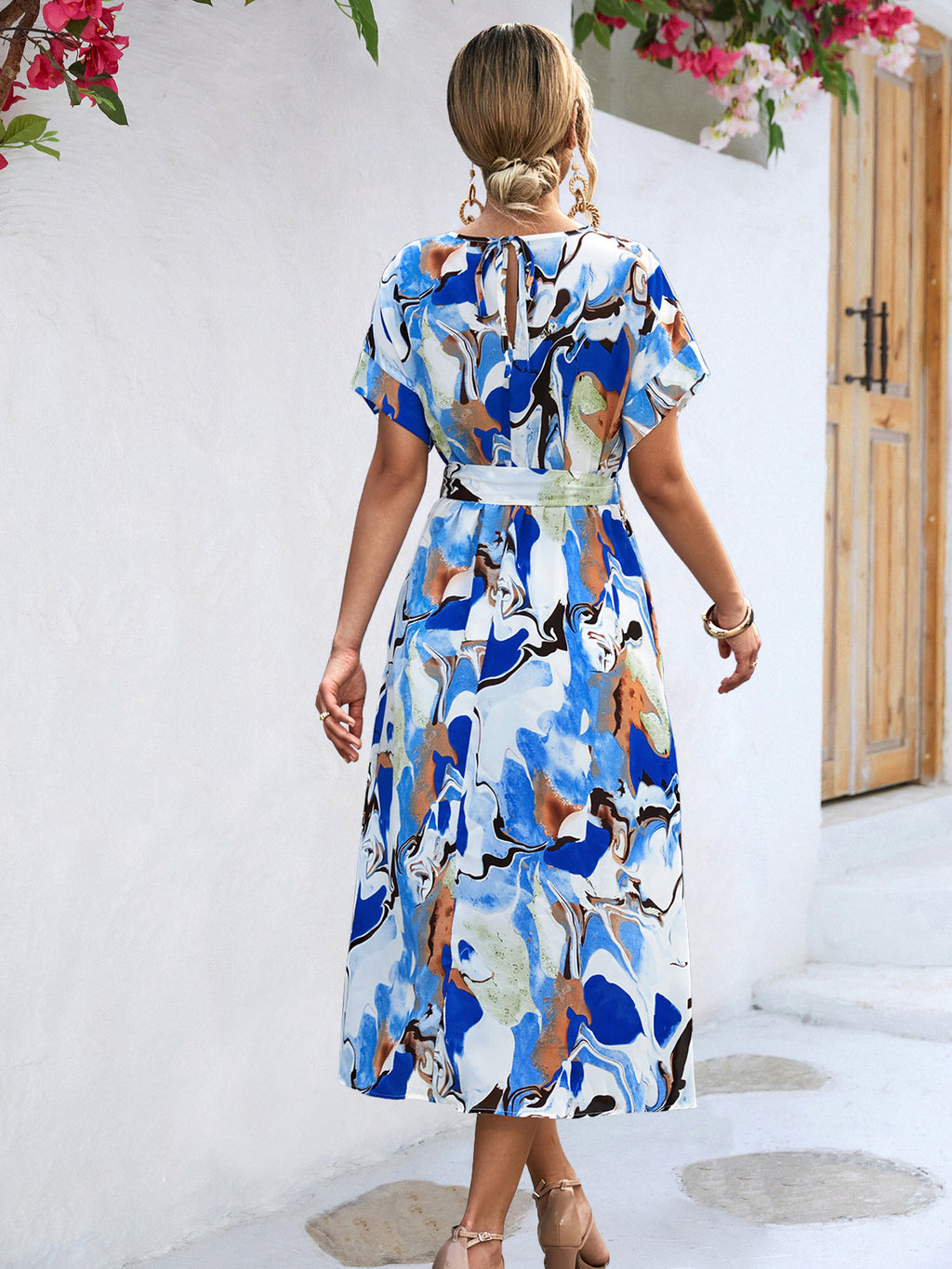 Back view of blue and white abstract print maxi dress with tied waist and cap sleeves