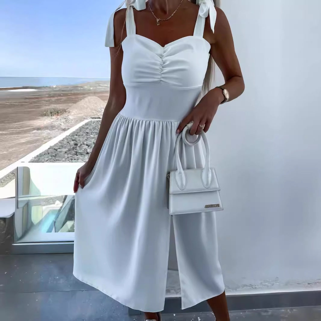 White sleeveless summer dress with bow-tie shoulder straps, button-front bodice and pockets