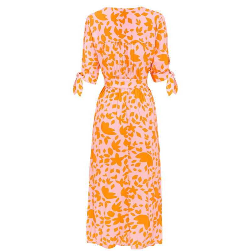 Orange leaf-print midi dress back view with tie cuffs and gathered waist