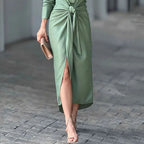 Green midi dress showing front slit and tied waist, long sleeves