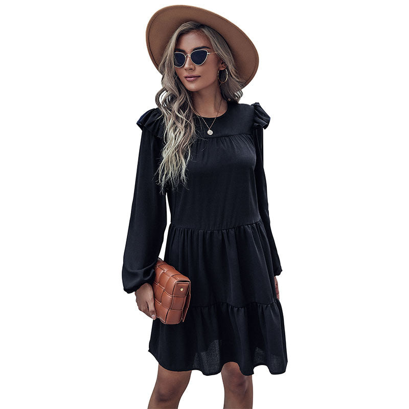 Black tiered mini dress with long sleeves and ruffled shoulder accents