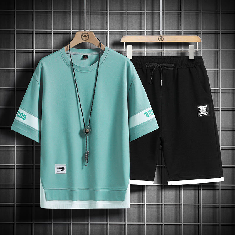 Men’s lounge set: teal crewneck shirt and black drawstring shorts with long necklace