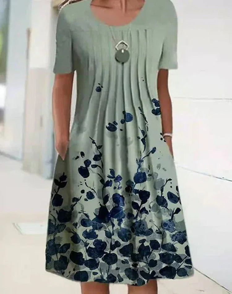 Casual mint green floral dress with dark blue blossoms, round neckline, and gathered skirt