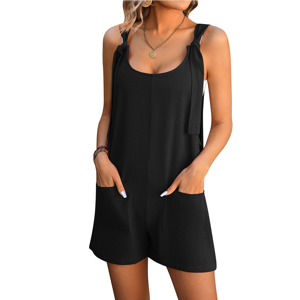 Black sleeveless playsuit with tie shoulder straps and front pocket shorts.