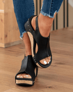 Women's black open-toe wedge sandals with ankle strap and stud details