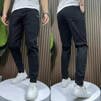 Men's black casual pants with zip fly, tapered legs, ankle-length hem, pockets