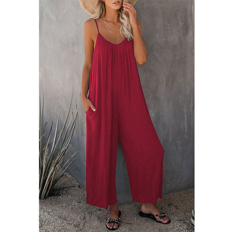 Pink-red loose jumpsuit with thin straps and wide, relaxed legs.