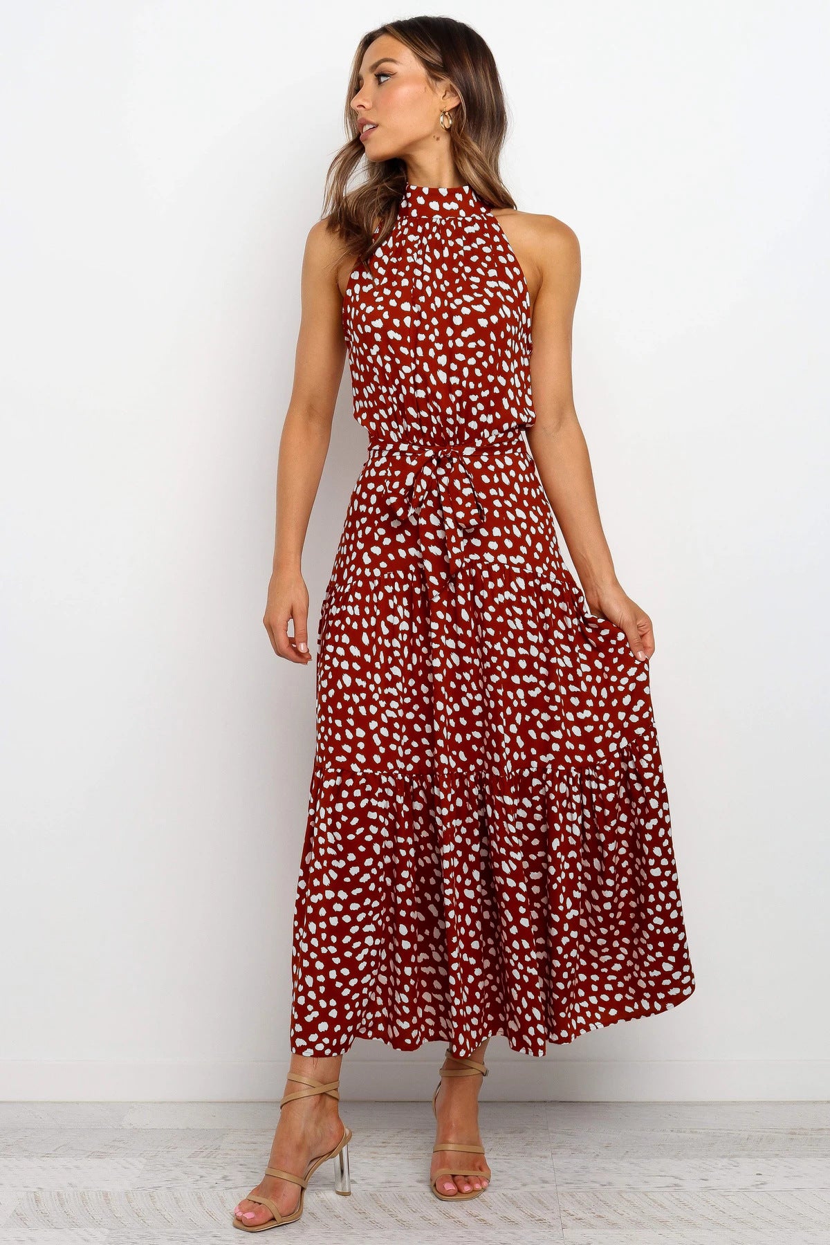 Red sleeveless halter long dress with white polka dots and tied waist