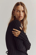 Black V-neck midi dress close-up showing ribbed texture and long sleeves