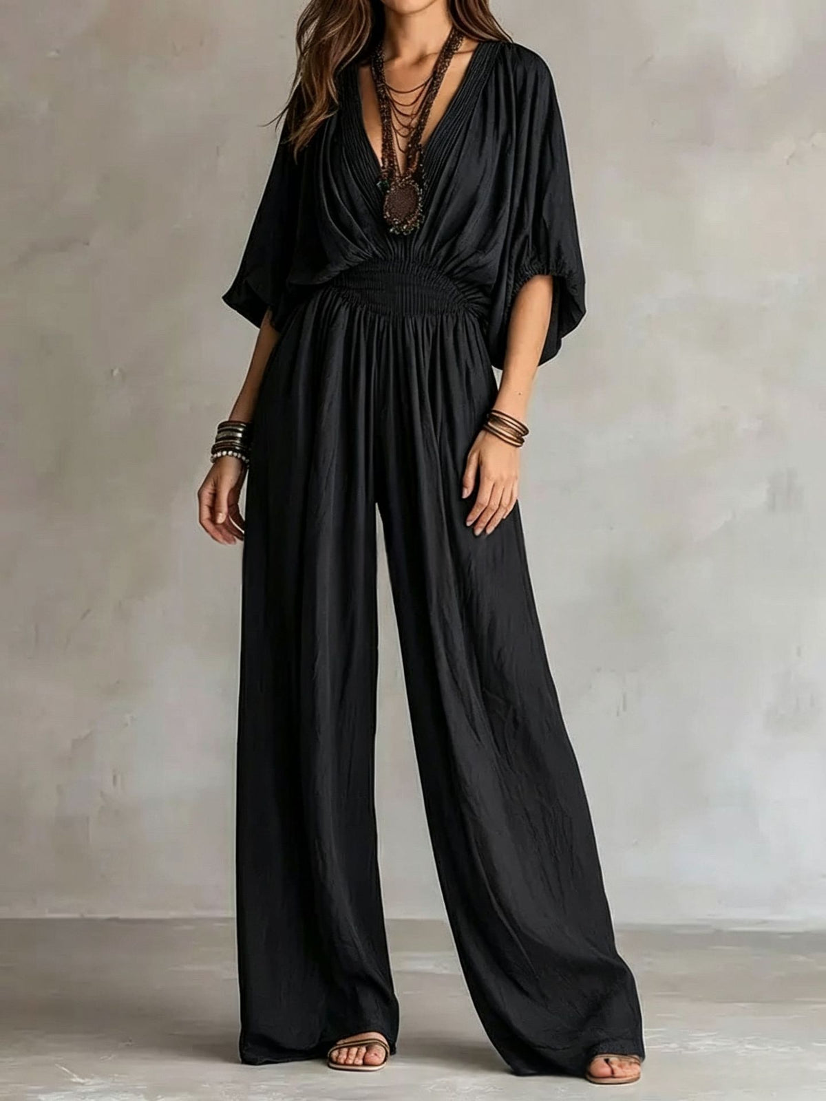 Black V-neck wide-leg jumpsuit with elastic waist and draped short sleeves