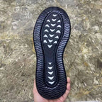 Black sneakers outsole view with wavy tread pattern