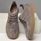 Suede lace-up sneakers with gum rubber sole, paired shoes on display