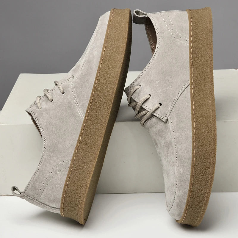 Suede lace-up sneakers with gum rubber sole, angled side view pair