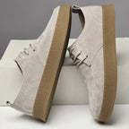 Suede lace-up sneakers with gum rubber sole, angled side view pair