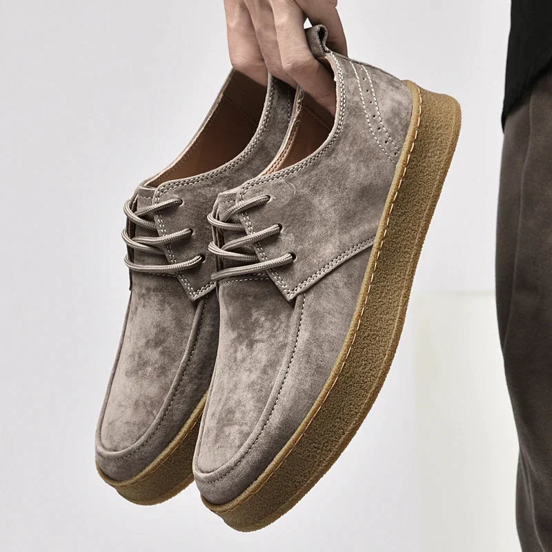Suede lace-up sneakers with round toe and gum rubber sole, side profile view