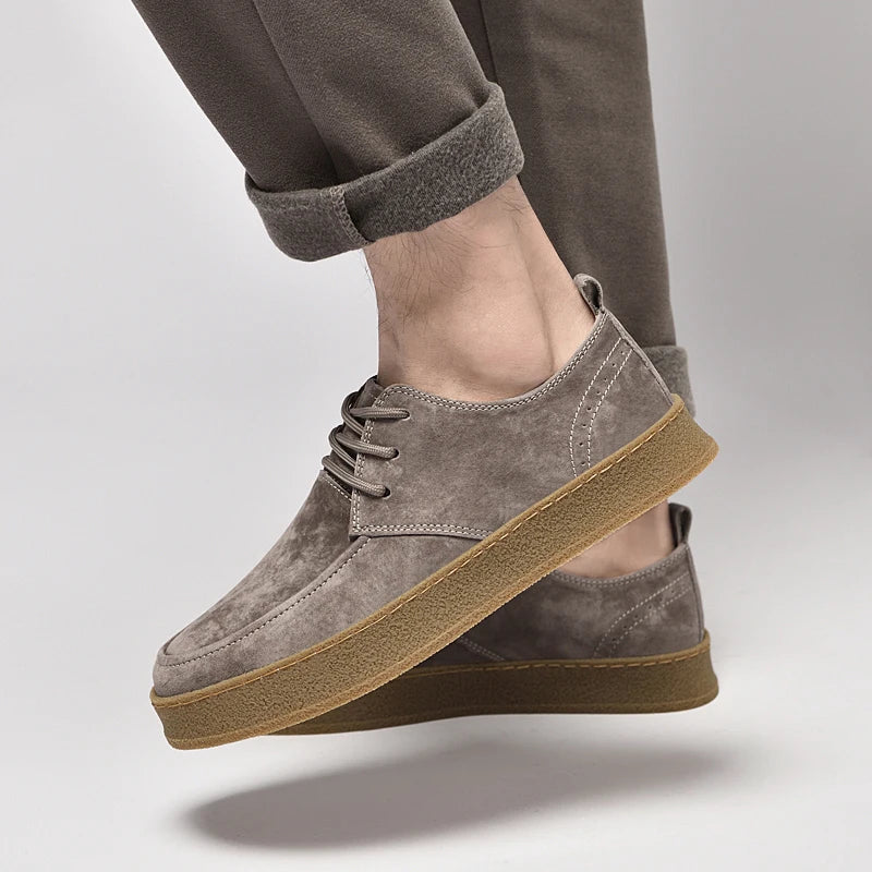 Suede lace-up sneakers with gum rubber sole, worn with pants and ankle view