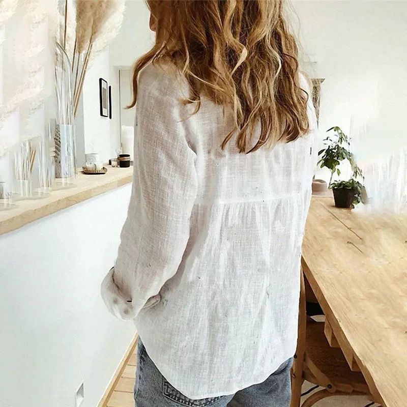 White casual button-down shirt with long sleeves and button front, slightly curved hem
