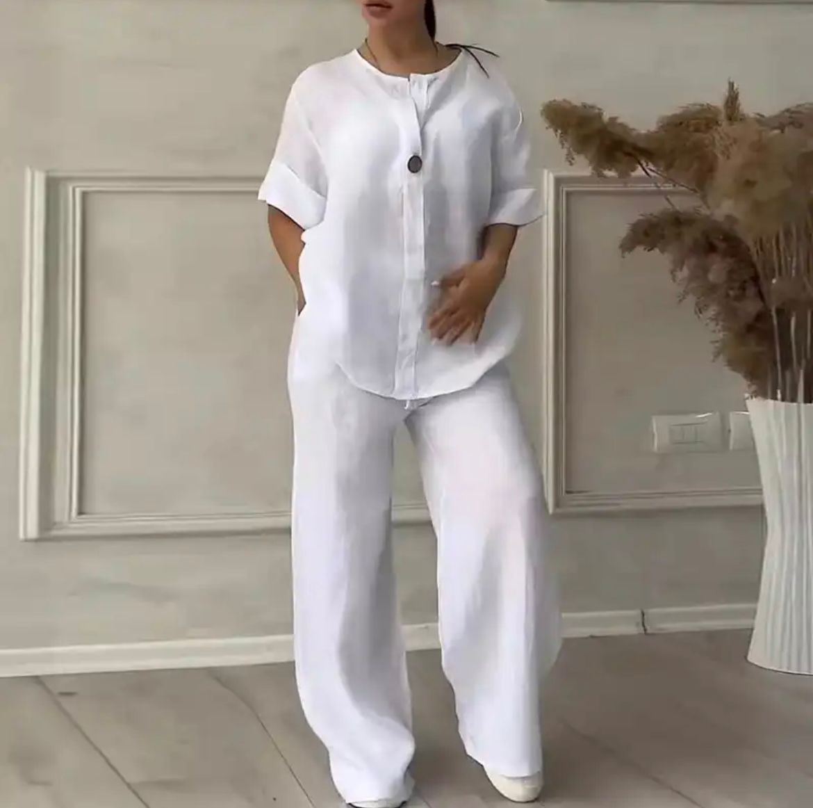 White linen lounge set with button-front short-sleeve top and wide-leg trousers