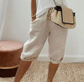 Beige cropped womens pants with drawstring waist and relaxed cuffs