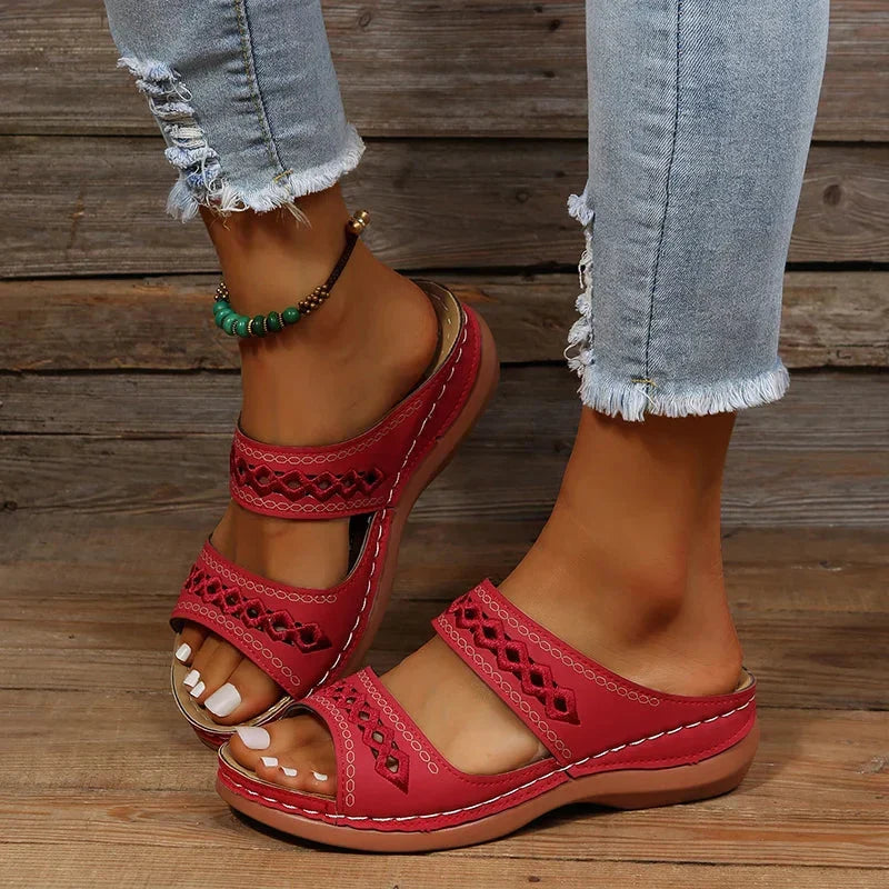 Red slide sandals with cutout stitched detail, two straps, and cushioned sole