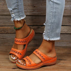 Orange slide sandals with cutout stitched detail, two straps, and cushioned sole