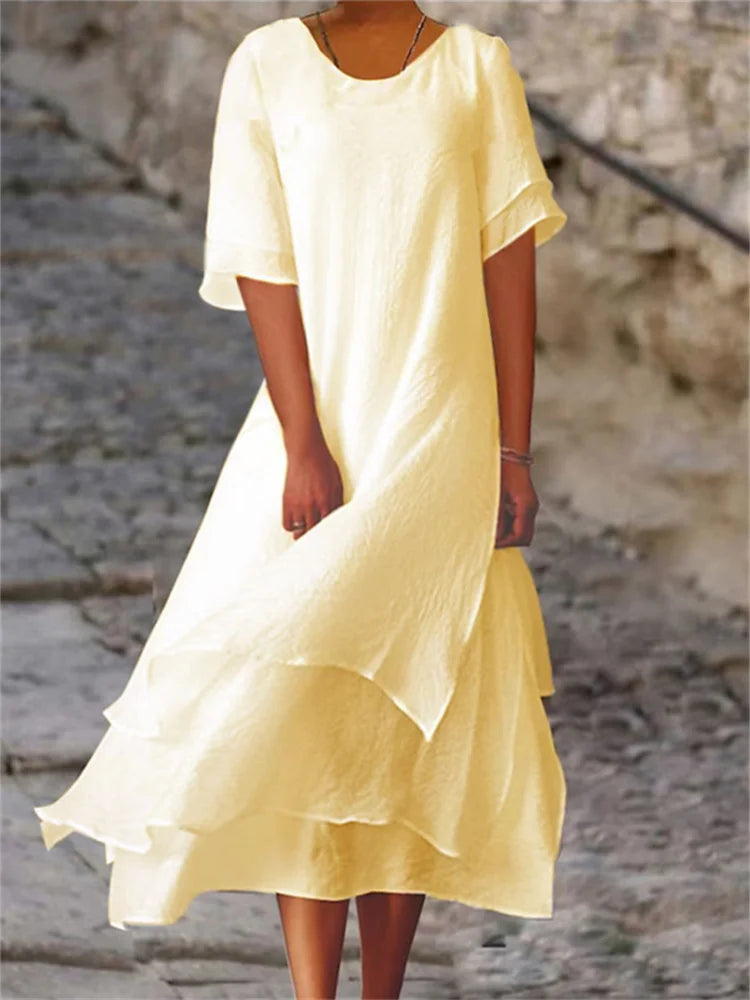 Pale yellow long midi dress with short sleeves, round neck, and layered ruffle hem