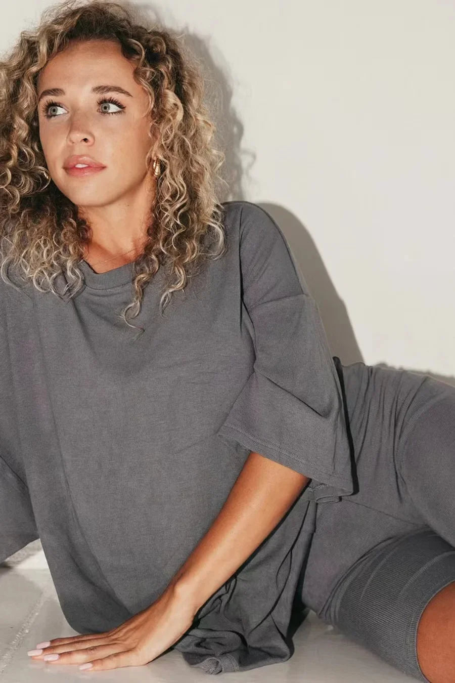 Women’s dark gray lounge set with short-sleeve top and matching biker shorts.