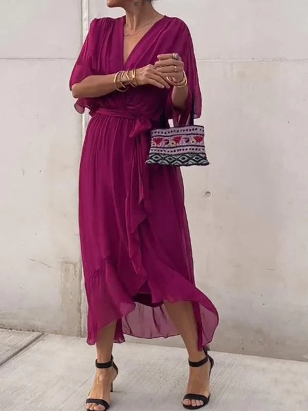 Magenta V-neck wrap summer dress with waist tie and asymmetrical chiffon hem.