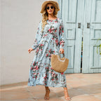 Light blue floral maxi dress with long sleeves, gathered waist, and tiered skirt
