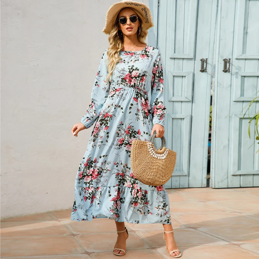 Light blue floral maxi dress with long sleeves, gathered waist, and tiered skirt