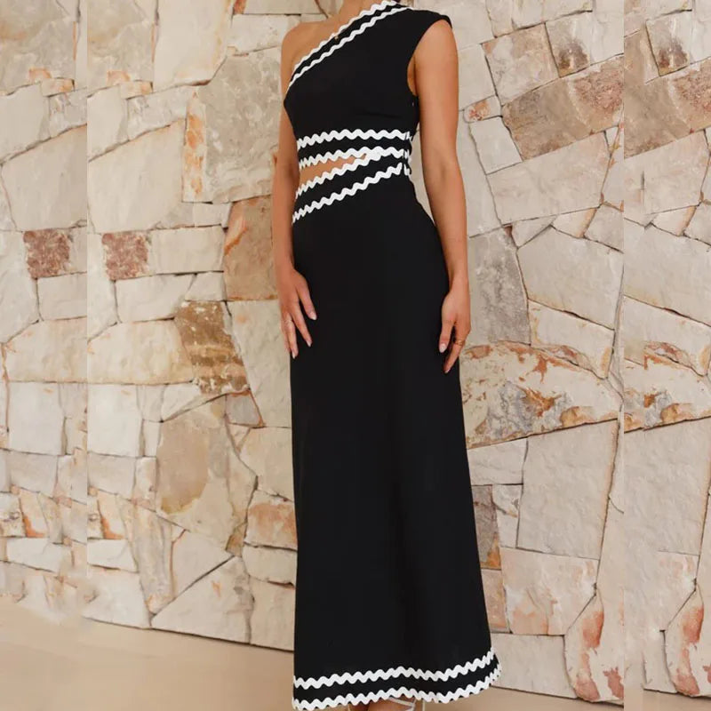 Black sleeveless one-shoulder maxi dress with zigzag trim at neckline, waist, and hem