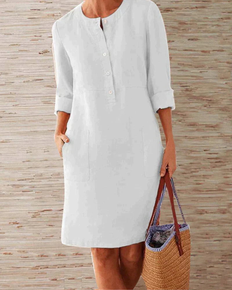 White button-front summer dress with three-quarter sleeves and side pockets