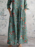 Teal patterned maxi dress with V-neck, tiered skirt, three-quarter sleeves